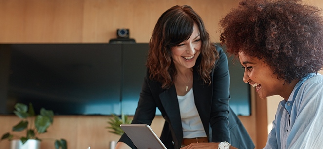 two woman smiling in the office