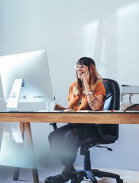 Woman at desk, on phone