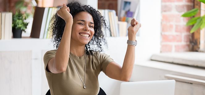 woman smiling and raising her arms in celebration