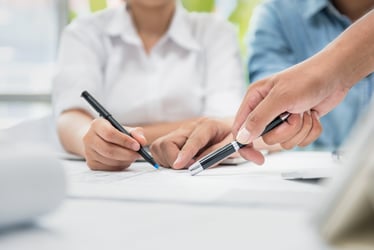 Project management stock image - people gathered around a document and making edits