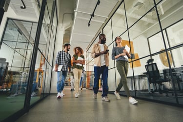 4 professionals walking in office hallway 