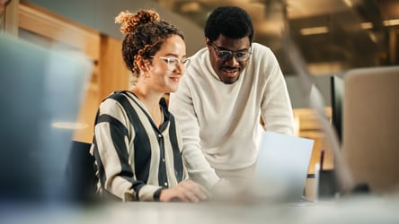 man and woman analyzing their association mangement software in office environment